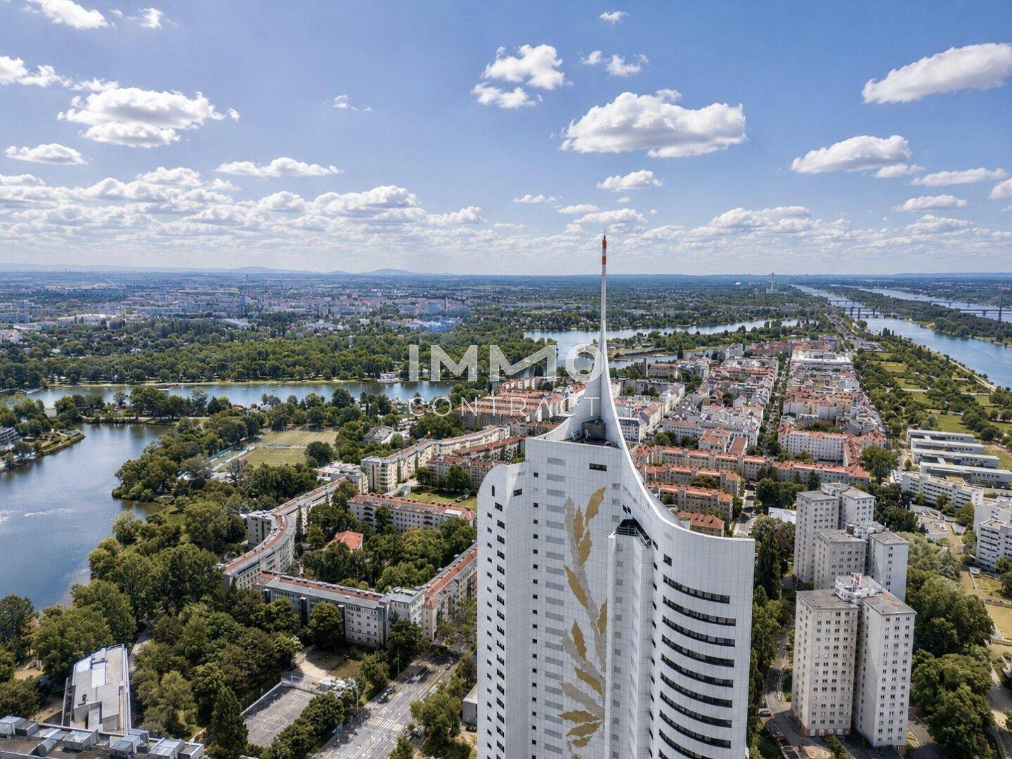 Luftaufnahme eines markanten Hochhauses mit einzigartiger Architektur und weitem Blick über die Stadt und den Fluss.