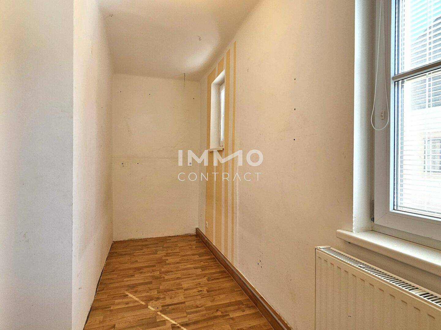 Kleiner Raum mit Laminatboden und Fenster, ideal als Abstellraum oder kleines Büro nutzbar.