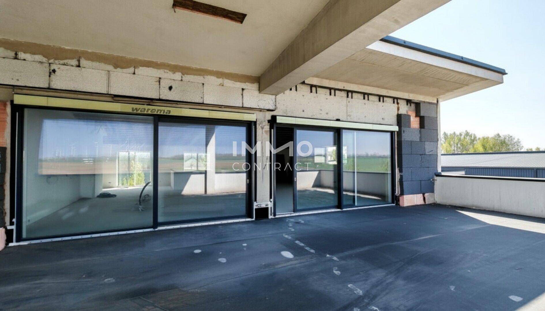 Große überdachte Terrasse im Rohbau mit weitem Blick und großen Glasschiebetüren.