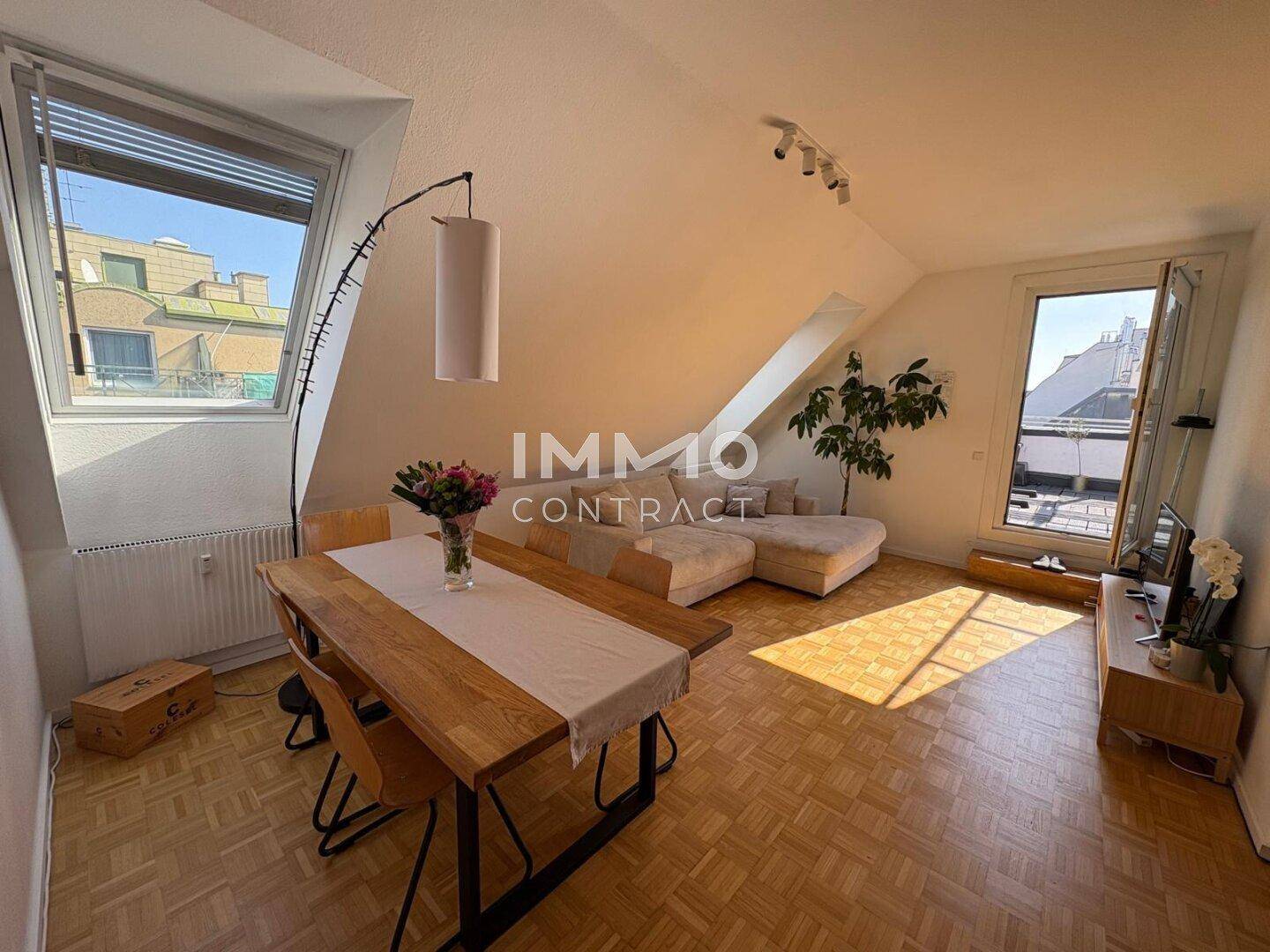 Heller Wohn-Essbereich im Dachgeschoss mit Holzboden und Zugang zur Dachterrasse.