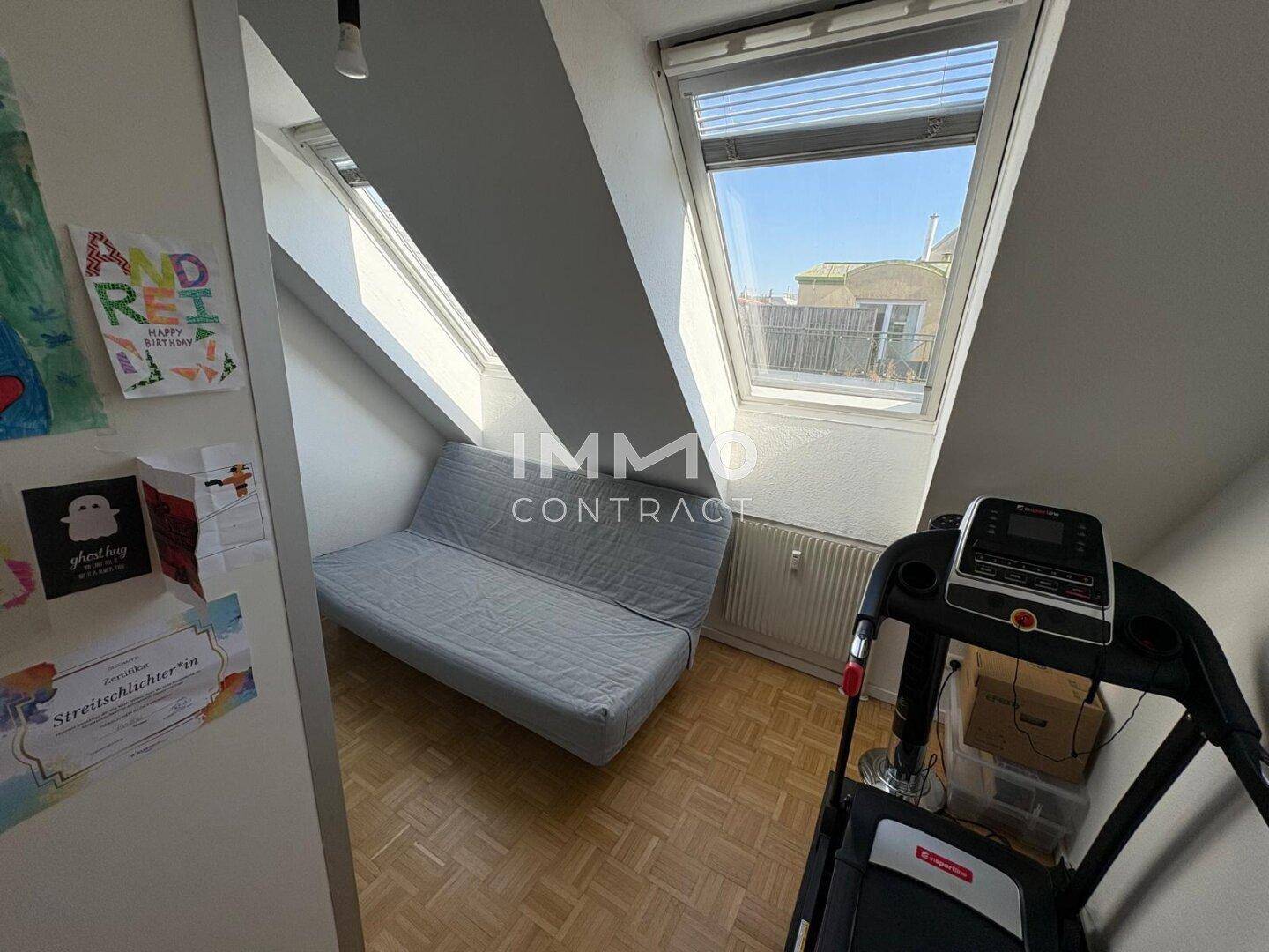 Helles Zimmer im Dachgeschoss mit Schlafsofa, Laufband und Dachfenstern.