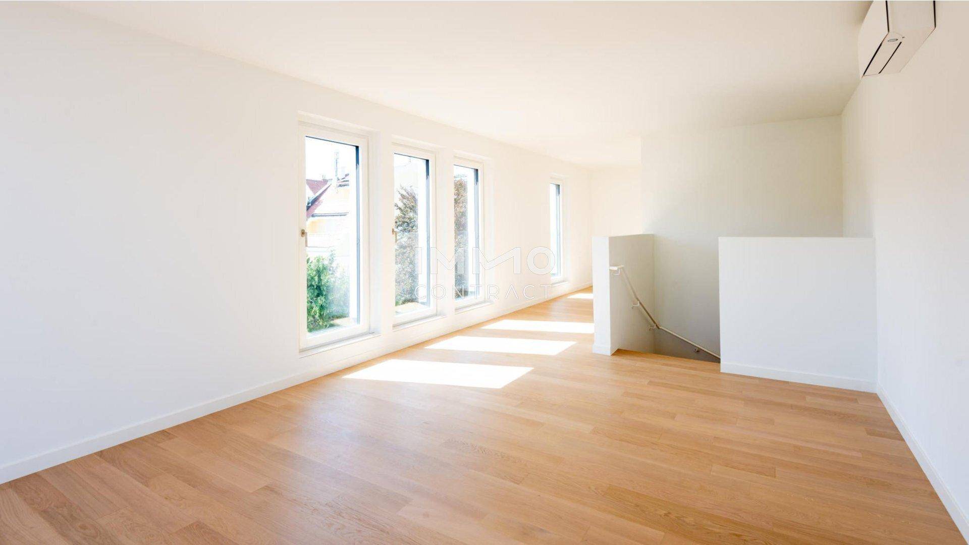 Geräumiger, heller Wohnbereich mit Parkettboden, großen Fenstern und viel Tageslicht.