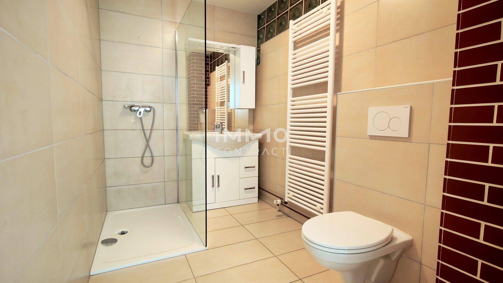 Modernes Badezimmer mit ebenerdiger Dusche, Wand-WC und beheiztem Handtuchhalter.