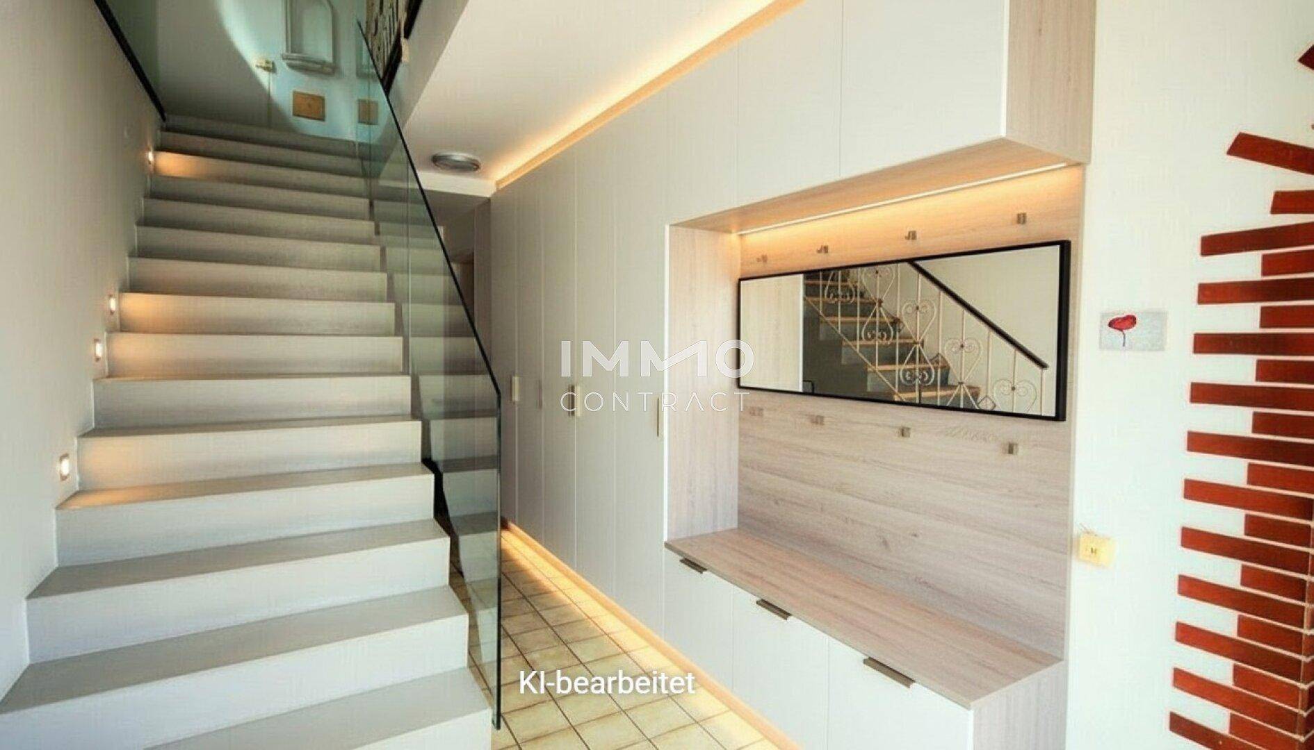 Renovierter Flur mit moderner Einbaumöblierung, indirekter Beleuchtung und Treppe.