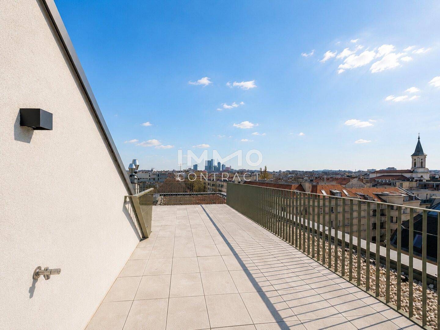 Weitläufige Dachterrasse mit Fliesenboden und Geländer, bietet einen beeindruckenden Panoramablick über die Stadt.