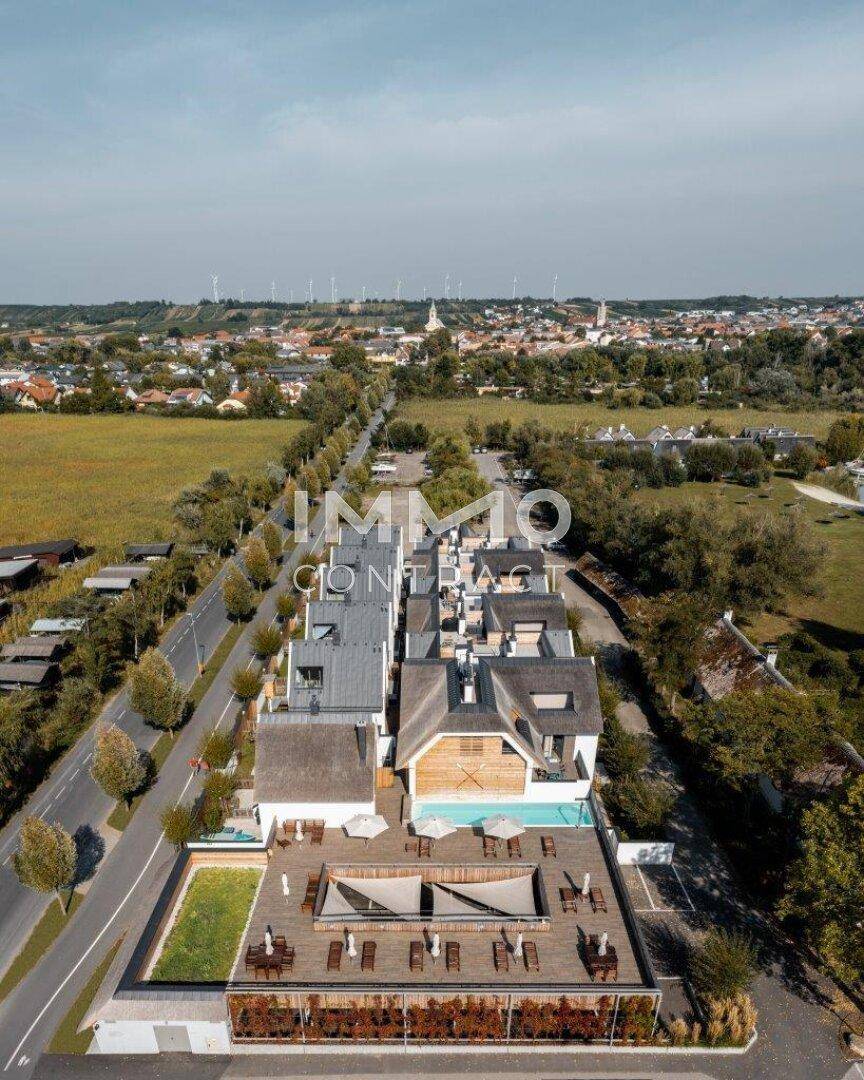 Luftaufnahme der modernen Wohnanlage mit Pool, Terrassen und Blick auf die umliegende Landschaft.
