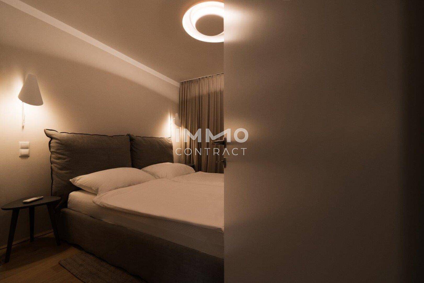 Schlafzimmer mit großem Bett und indirekter Beleuchtung, bietet eine ruhige Atmosphäre.