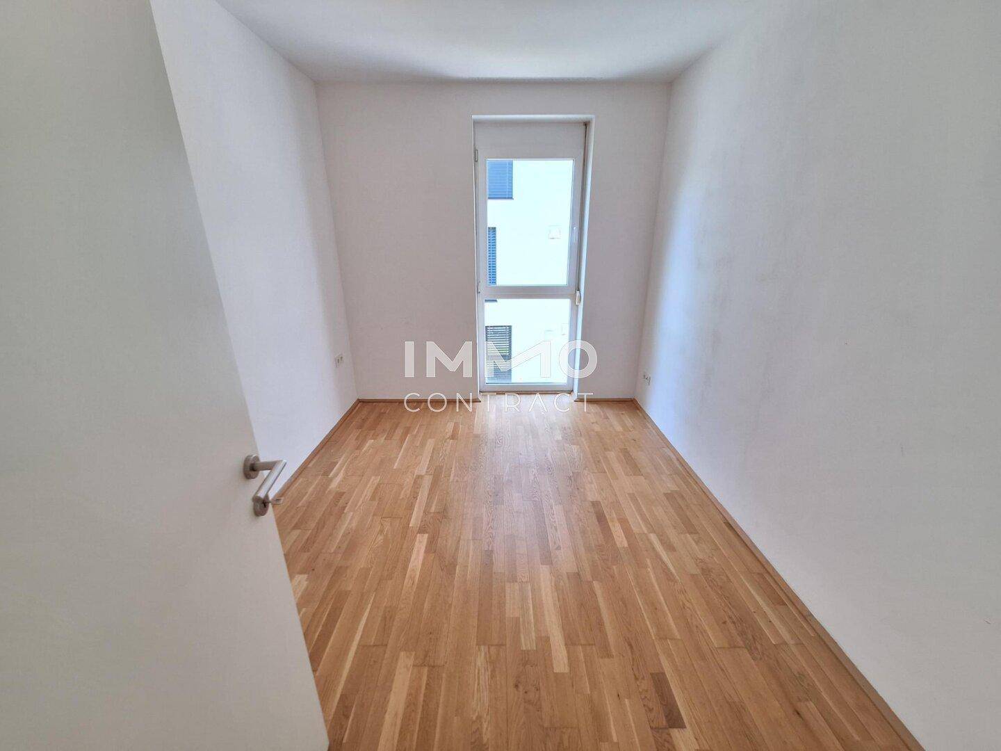 Kleines, helles Zimmer mit Holzboden und Fenster, ideal als Kinder- oder Arbeitszimmer.