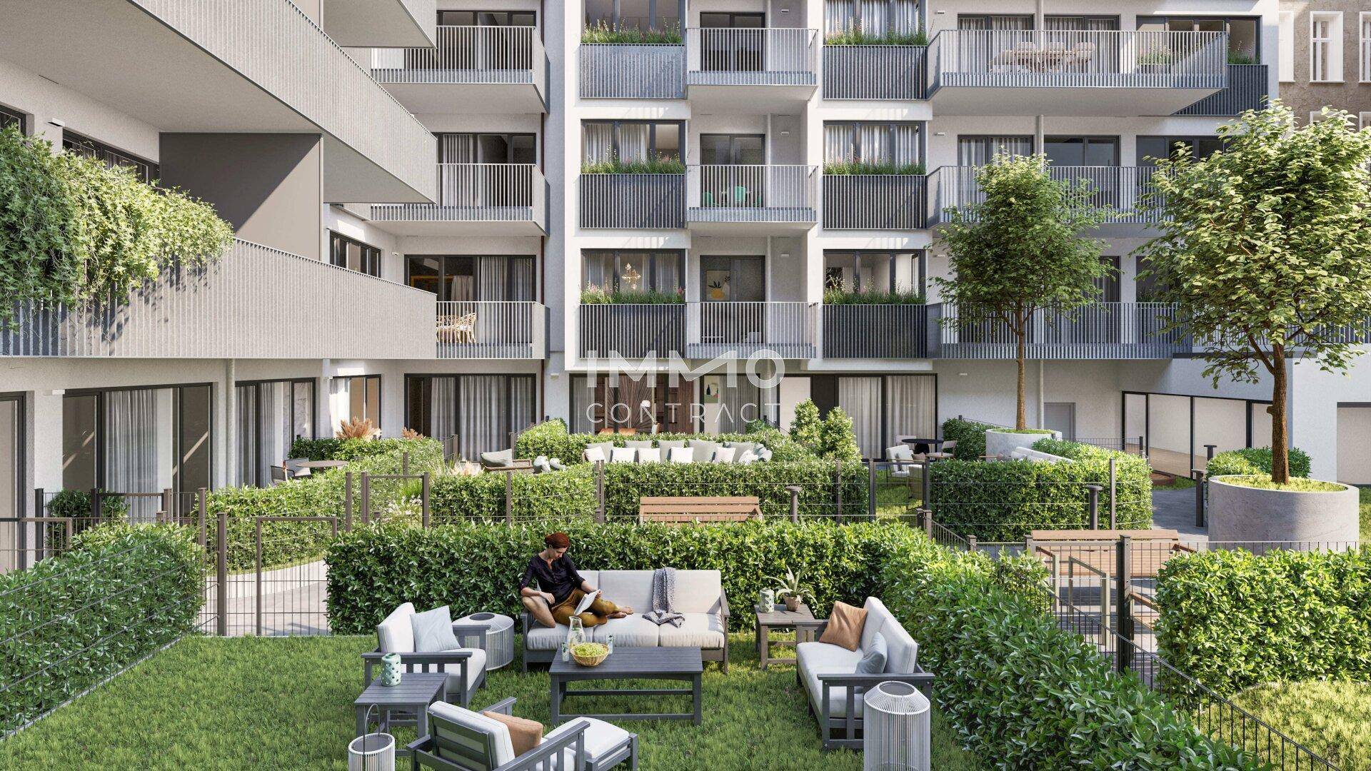 Begrünter Innenhof eines modernen Wohnkomplexes mit verschiedenen Sitzbereichen und Rasenflächen.