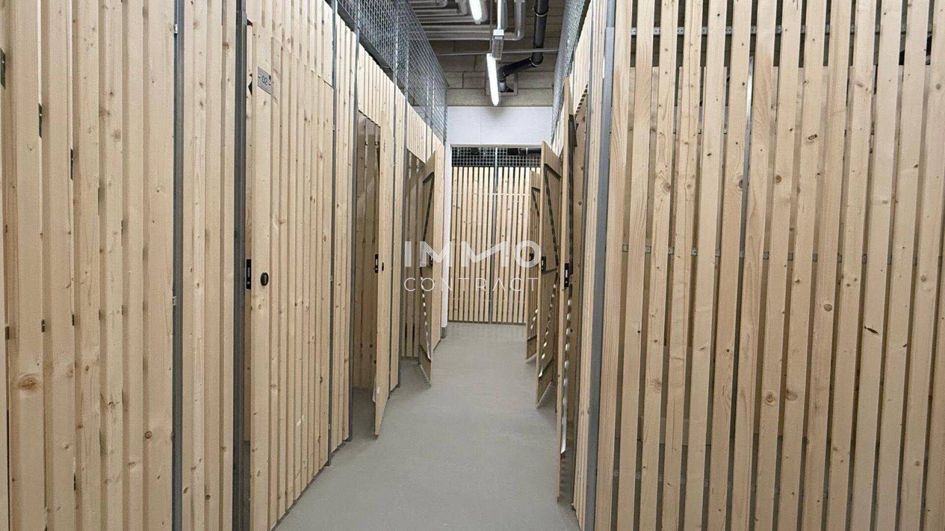 Abstellraum mit individuellen Holzverschlägen für zusätzlichen Stauraum im Kellerbereich.