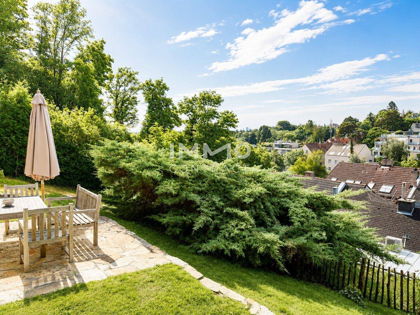 Sonniger Garten mit Sitzbereich und weitem Blick über die umliegende Wohngegend.