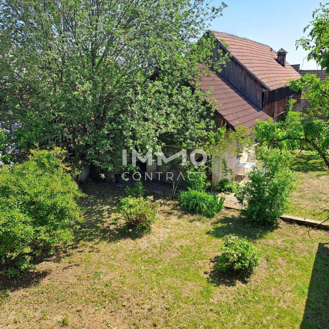 Gepflegter Garten mit Rasen, Sträuchern und Blick auf das Gebäude.