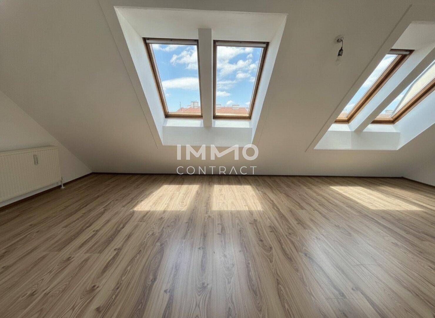Heller Dachgeschossraum mit Laminatboden und mehreren Dachfenstern, ideal für individuelle Gestaltung.