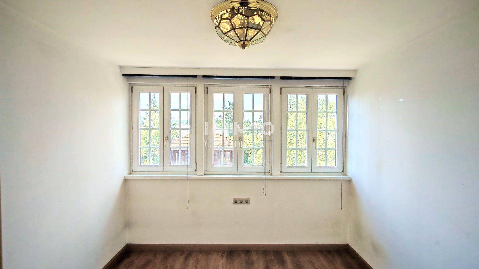 Helles Zimmer mit Holzboden und drei Fenstern, ideal als Büro oder Schlafzimmer nutzbar.