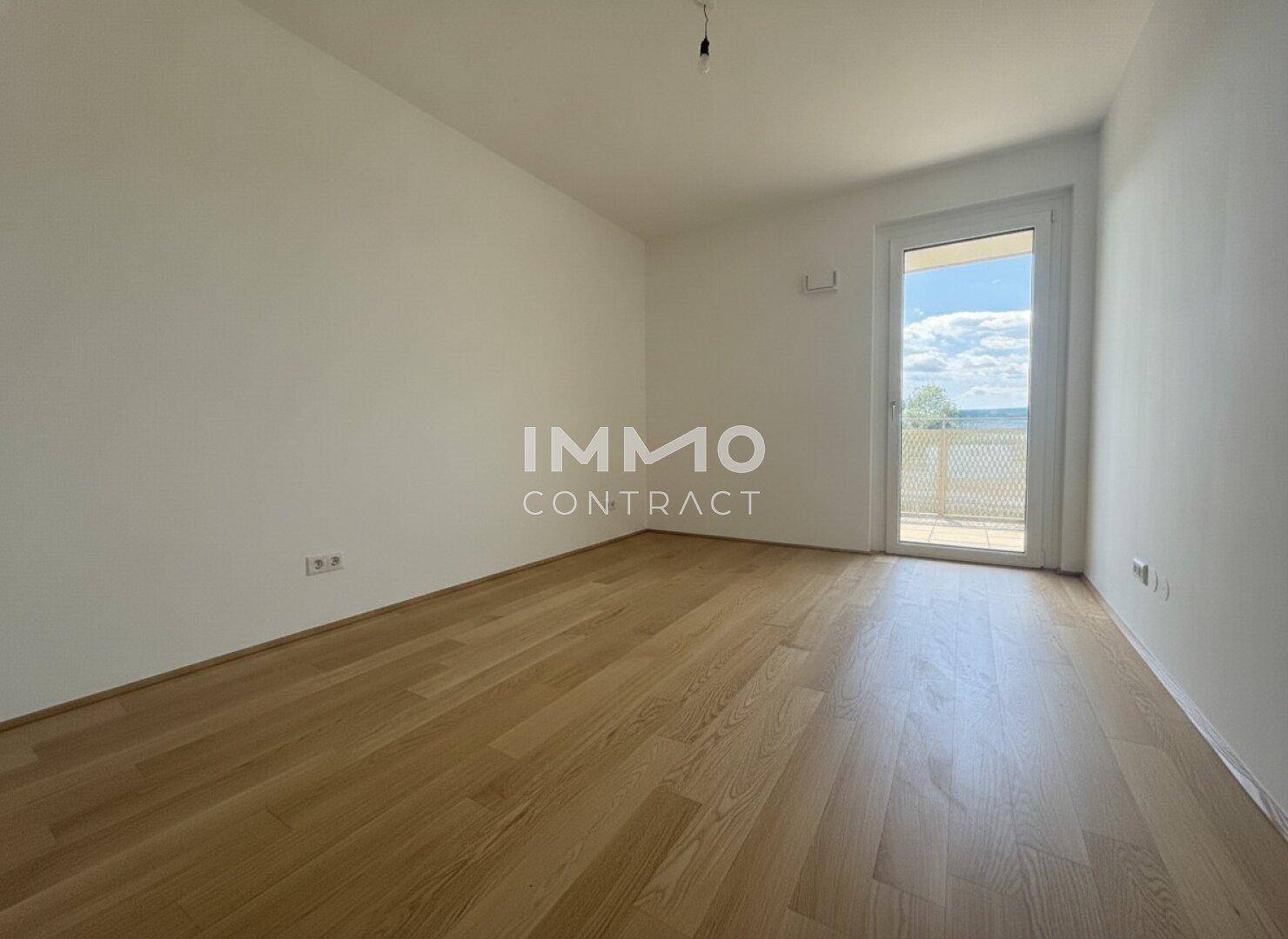 Helles Schlafzimmer mit Parkettboden und direktem Zugang zu einem Balkon, bereit zur Einrichtung.