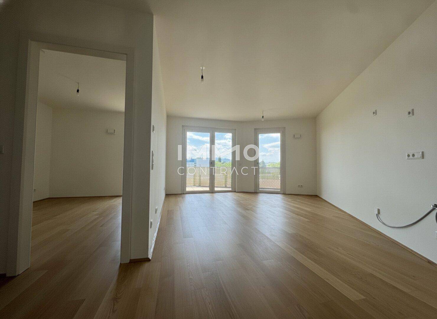 Heller, leerer Wohnraum mit Parkettboden und Zugang zu einem Balkon, ideal für individuelle Gestaltung.