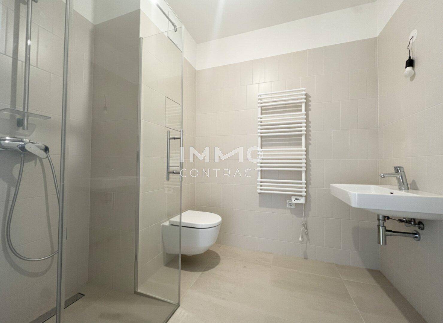 Modernes Badezimmer mit begehbarer Dusche, Wand-WC, Waschbecken und beheiztem Handtuchhalter.