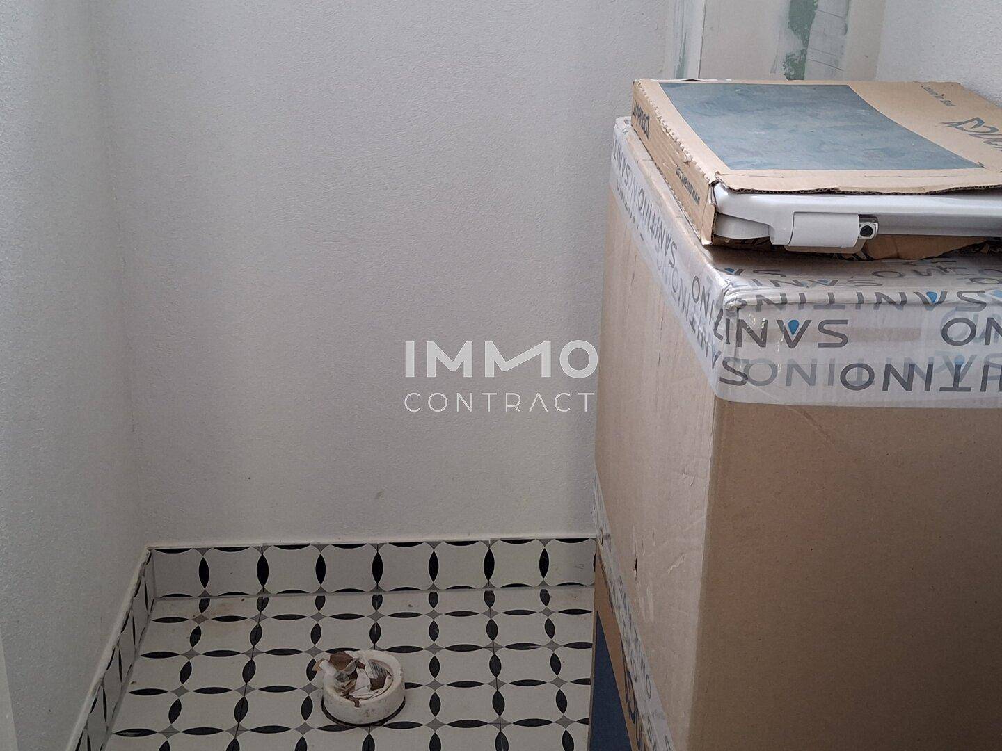 Badezimmerdetail mit gemusterten Fliesen am Boden und einer Toilette in Renovierung.