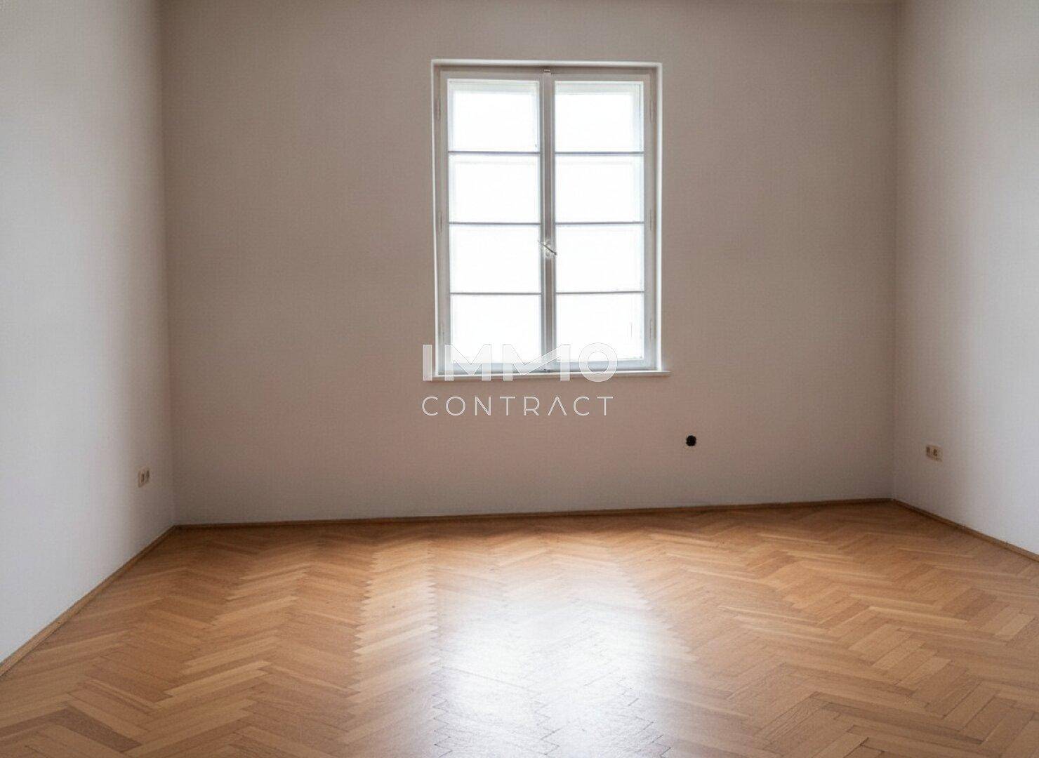 Helles Schlafzimmer mit Fischgrätparkett und einem großen Fenster, bereit zur individuellen Gestaltung.