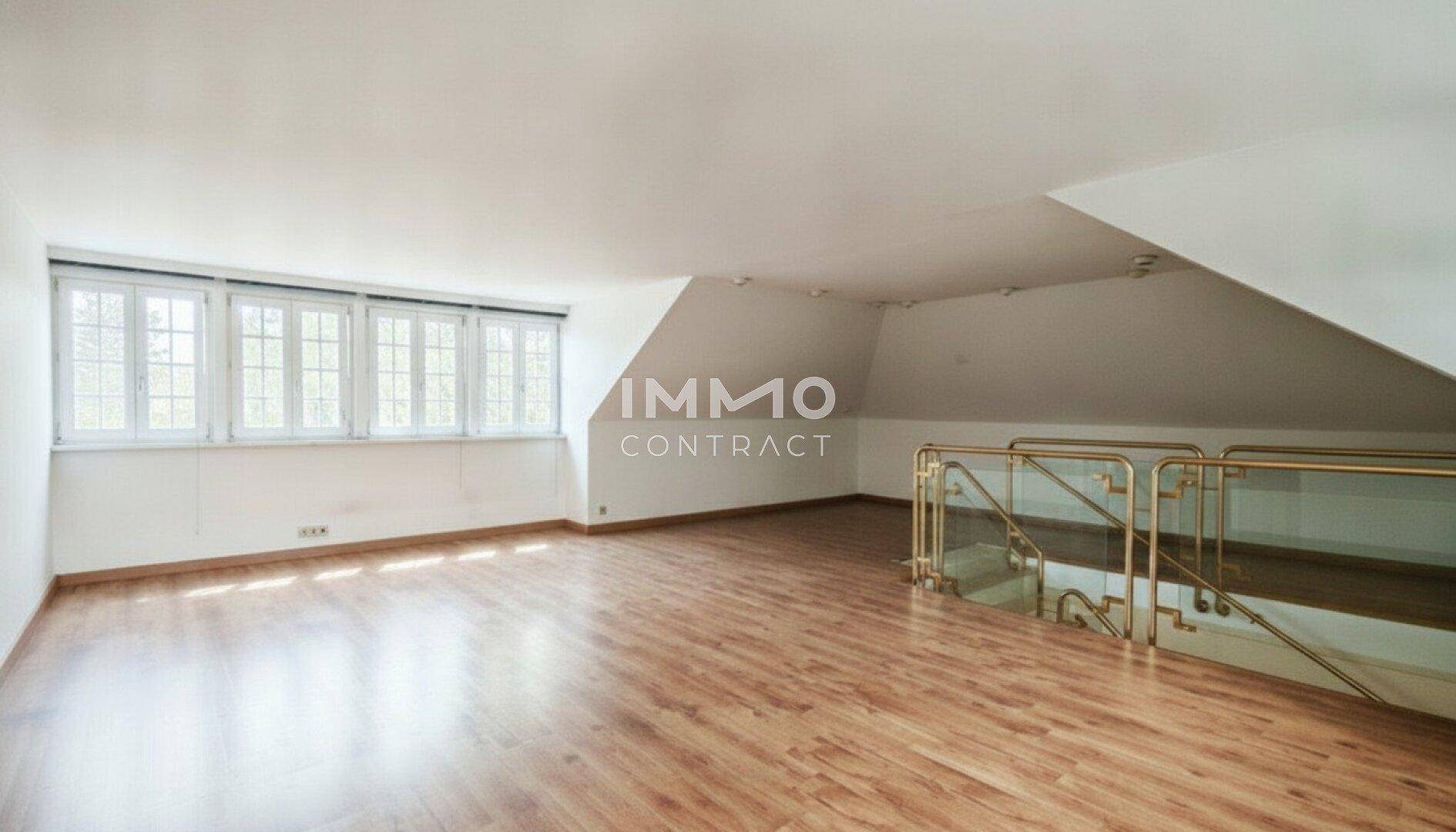 Geräumiger Dachbodenraum mit Holzboden und großen Fenstern, ideal für ein zusätzliches Zimmer.