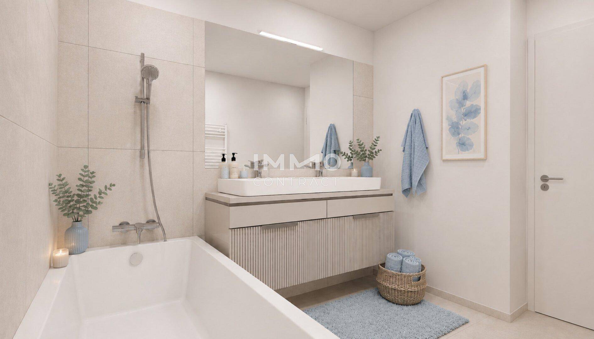 Modernes Badezimmer mit Badewanne, Waschtisch und großem Spiegel, hell gefliest.