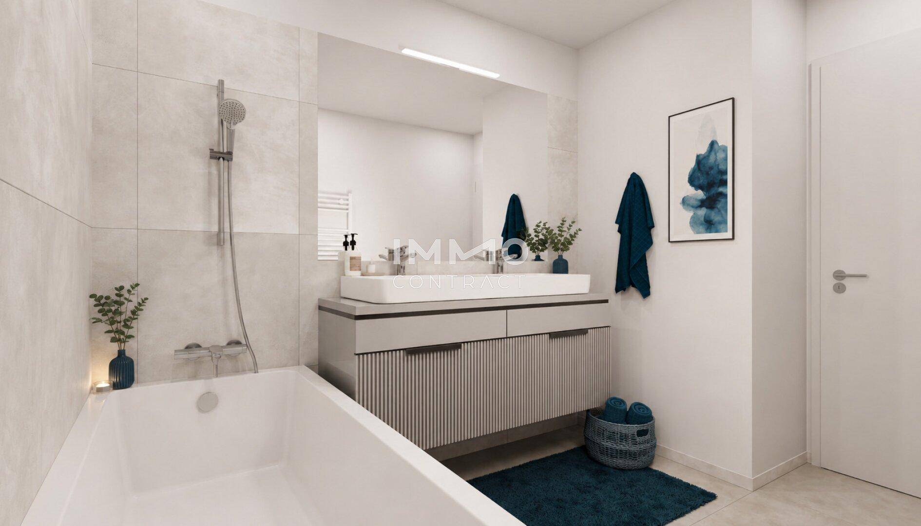 Modernes Badezimmer mit Badewanne, Einzelwaschbecken und hellen Fliesen an den Wänden.