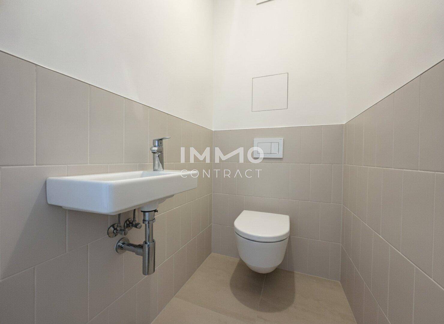 Kleines Gäste-WC mit wandhängender Toilette und modernem Waschbecken.