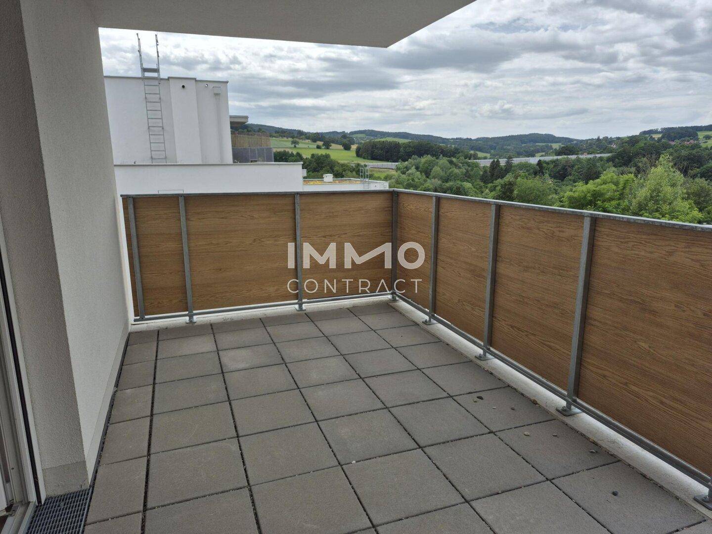 Geräumiger Balkon mit Fliesenboden und weitem Blick über die Landschaft.