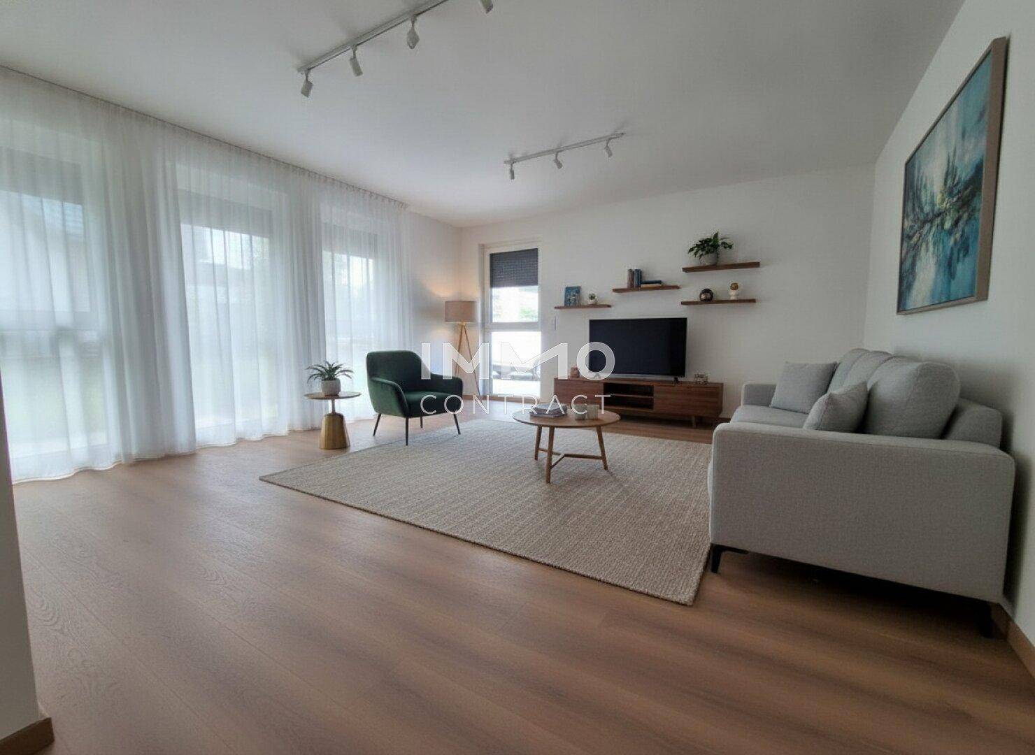 Helles Wohnzimmer mit Laminatboden, bequemer Couch, Fernseher und großen Fenstern mit Vorhängen.