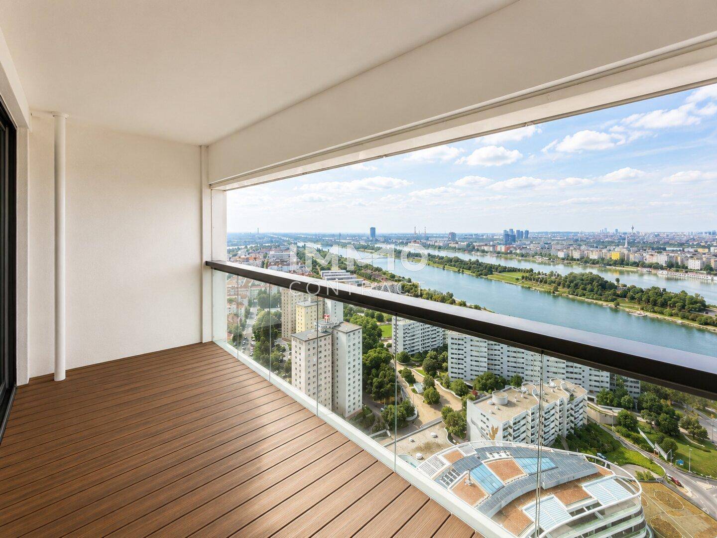 Geräumiger Balkon mit Holzboden und atemberaubendem Panoramablick über die Stadt und den Fluss.