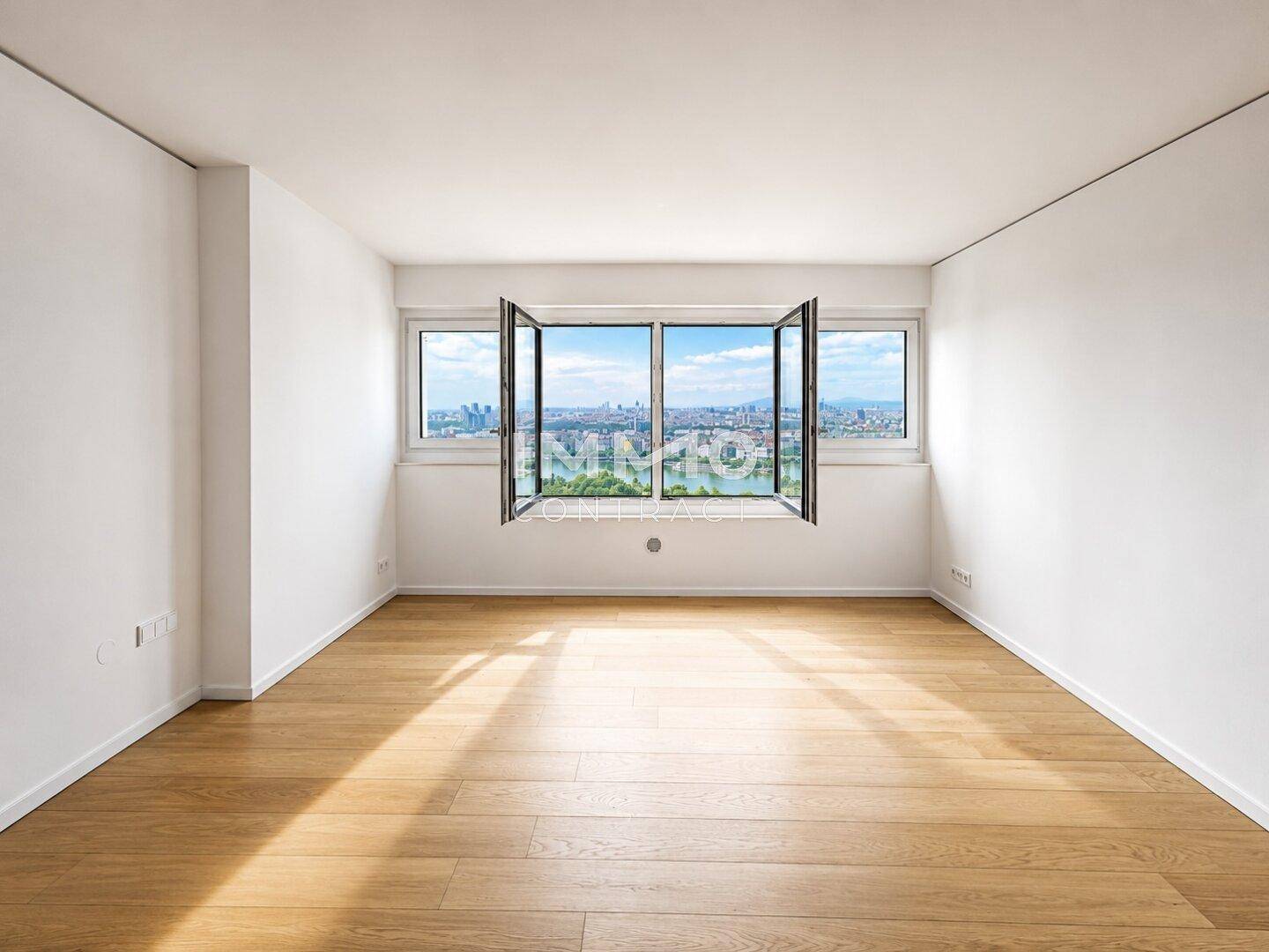 Lichtdurchflutetes Zimmer mit Holzboden und weitem Ausblick auf die Stadt und das Wasser.