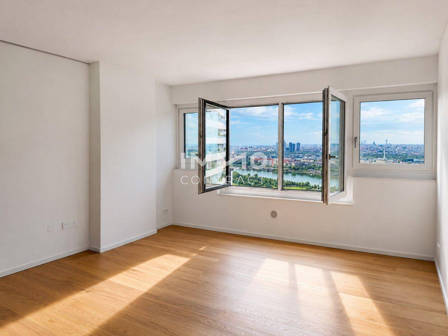 Helles Schlafzimmer mit Parkettboden und großen Fenstern, die einen weiten Blick auf die Stadt bieten.