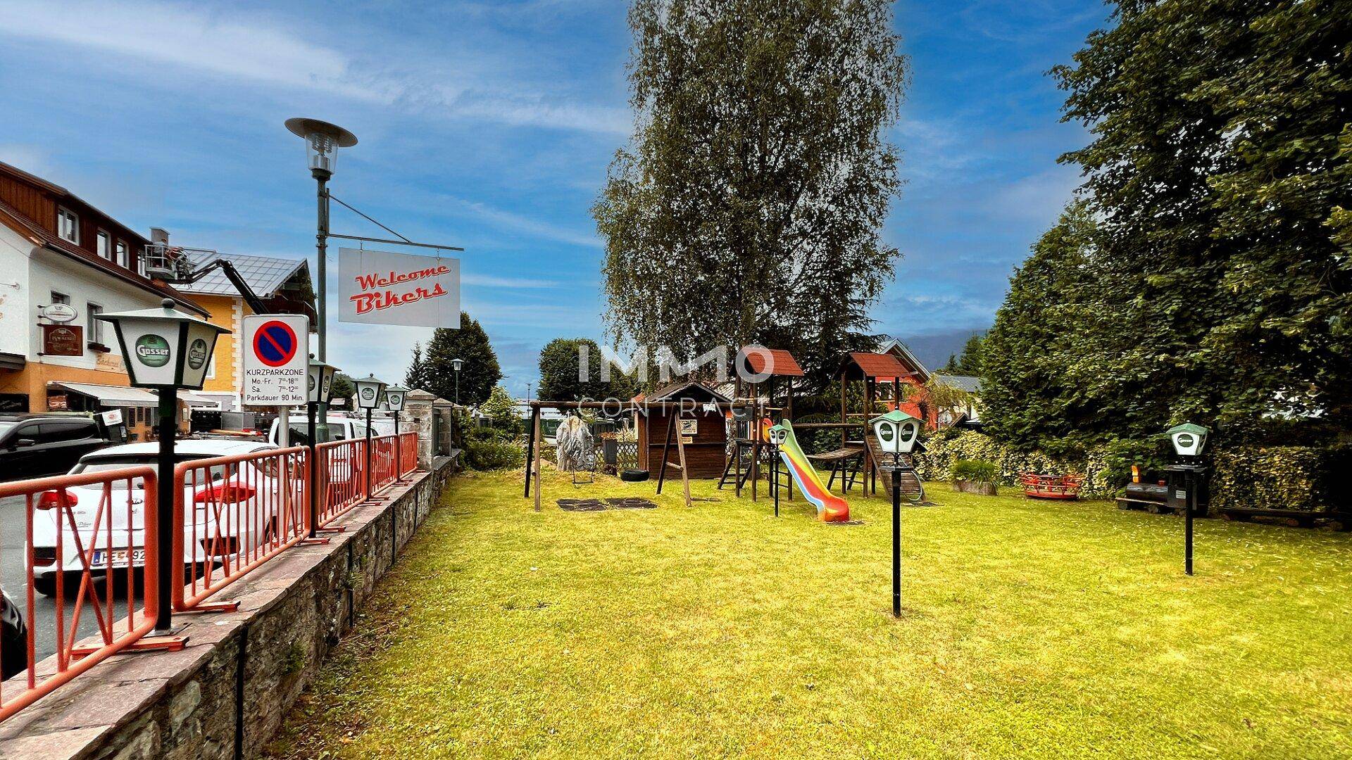 Großer Gartenbereich mit Kinderspielplatz, Rutsche und Schaukeln.