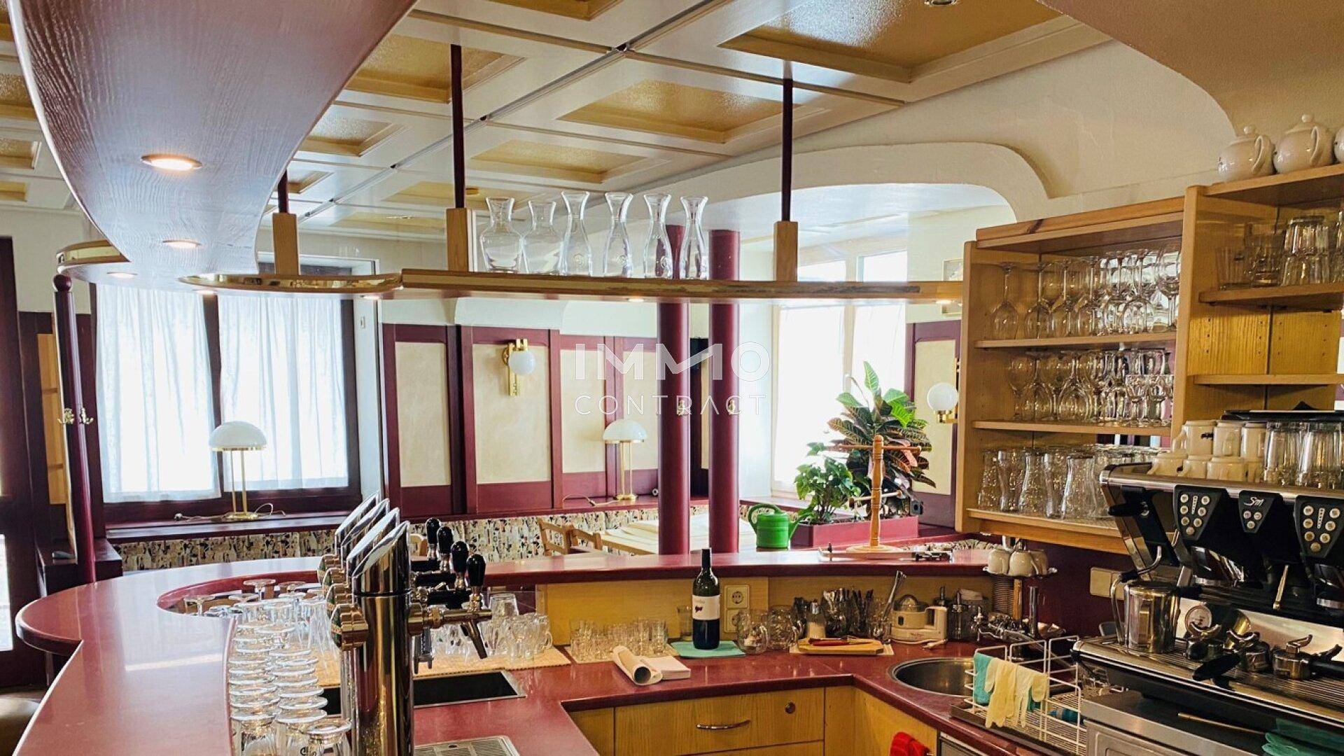 Gut ausgestatteter Barbereich mit Zapfanlage, Gläsern und traditioneller Deckenverkleidung.