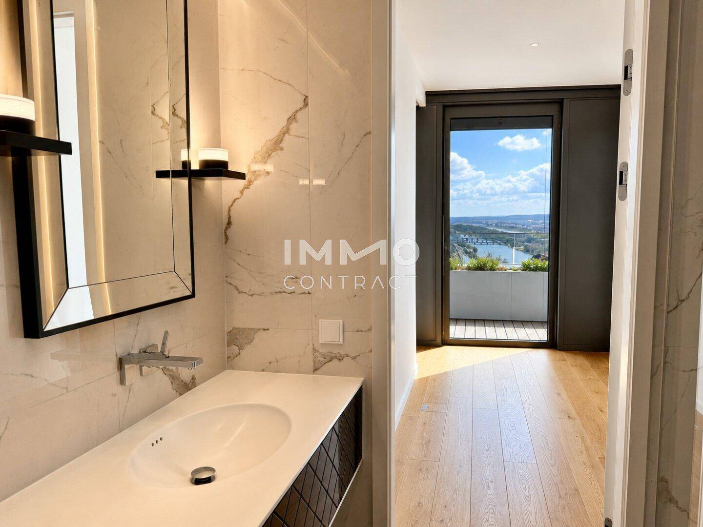 Elegantes Badezimmer mit Marmorwänden, modernem Waschbecken und Zugang zu einem Raum mit Panoramablick.