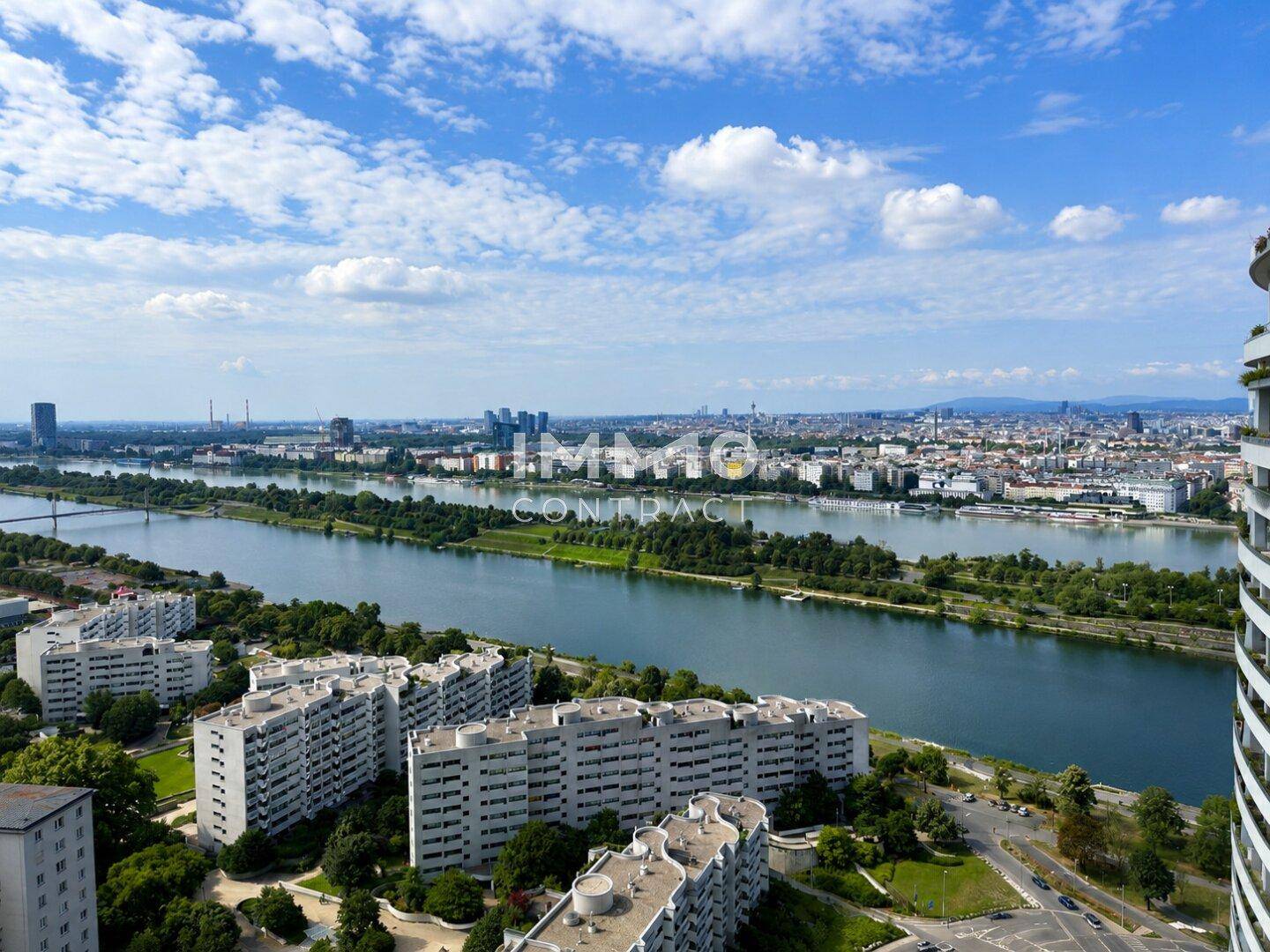 Weitläufiger Panoramablick auf die Stadt, den Fluss und die umliegende Bebauung unter blauem Himmel.