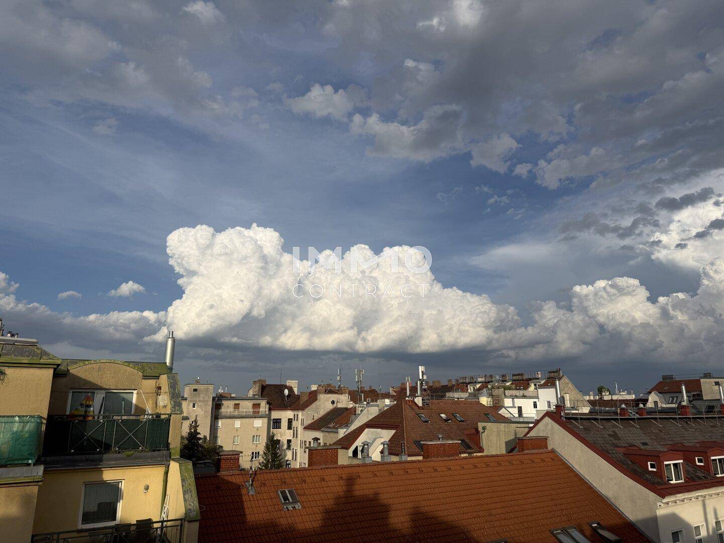 Panoramablick über die Stadt mit einer beeindruckenden Wolkenformation am Himmel.