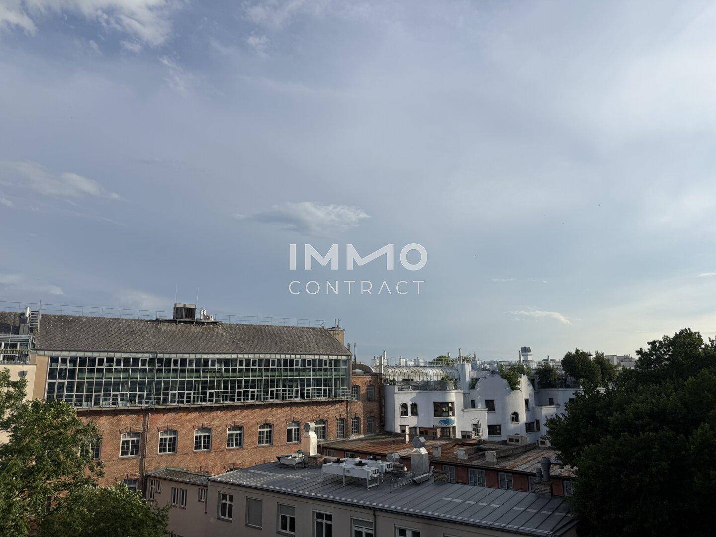 Weitblick über die städtische Bebauung mit verschiedenen Gebäuden und einem bewölkten Himmel.