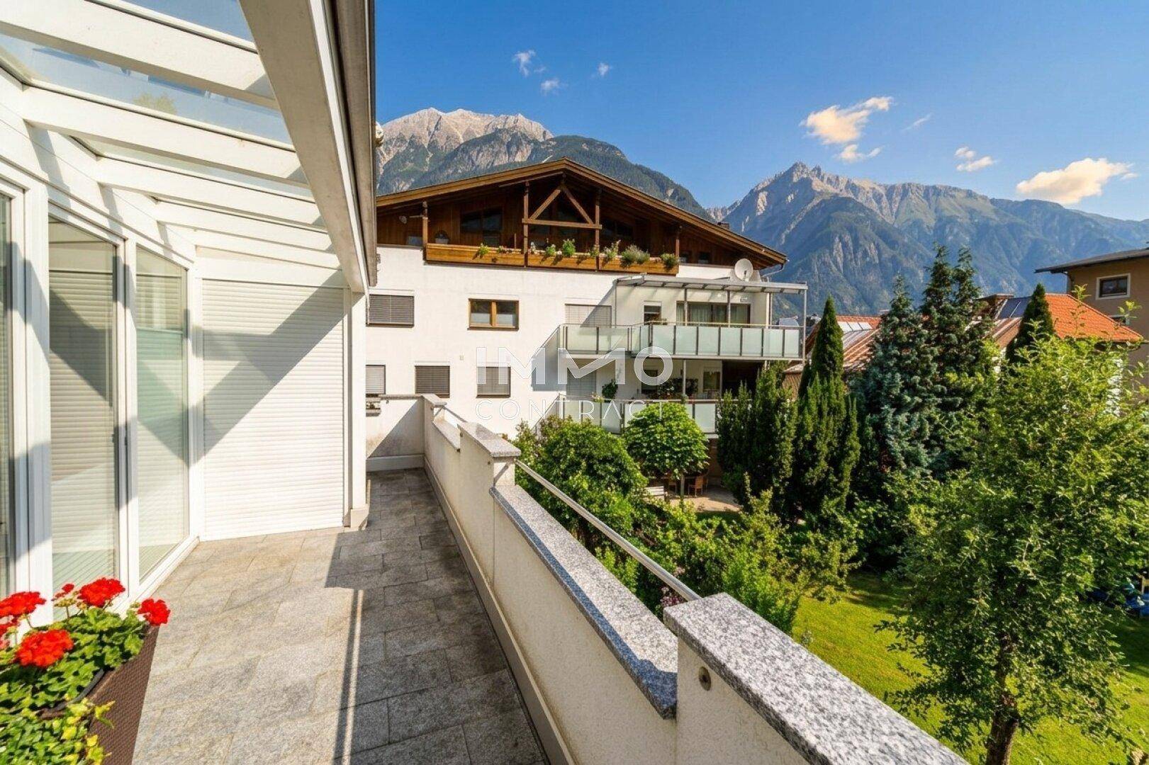 Langer Balkon mit Steinboden, Geländer und atemberaubendem Bergblick.