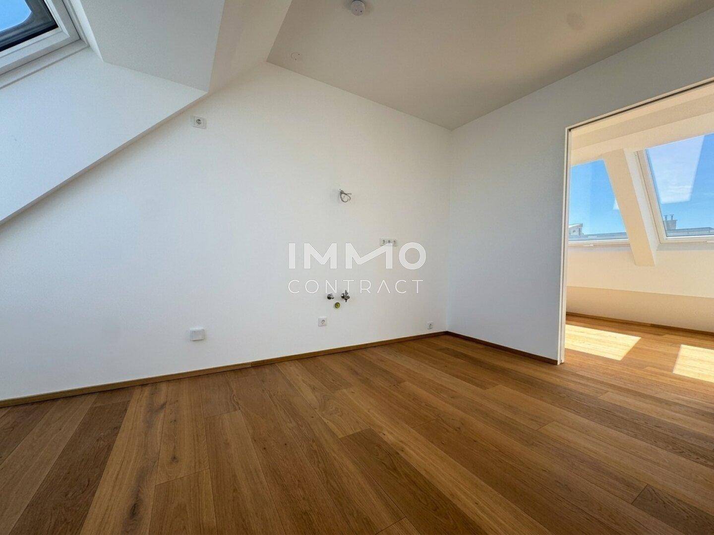 Helles Schlafzimmer mit Dachschrägen, Holzboden und Dachfenstern für viel Tageslicht.