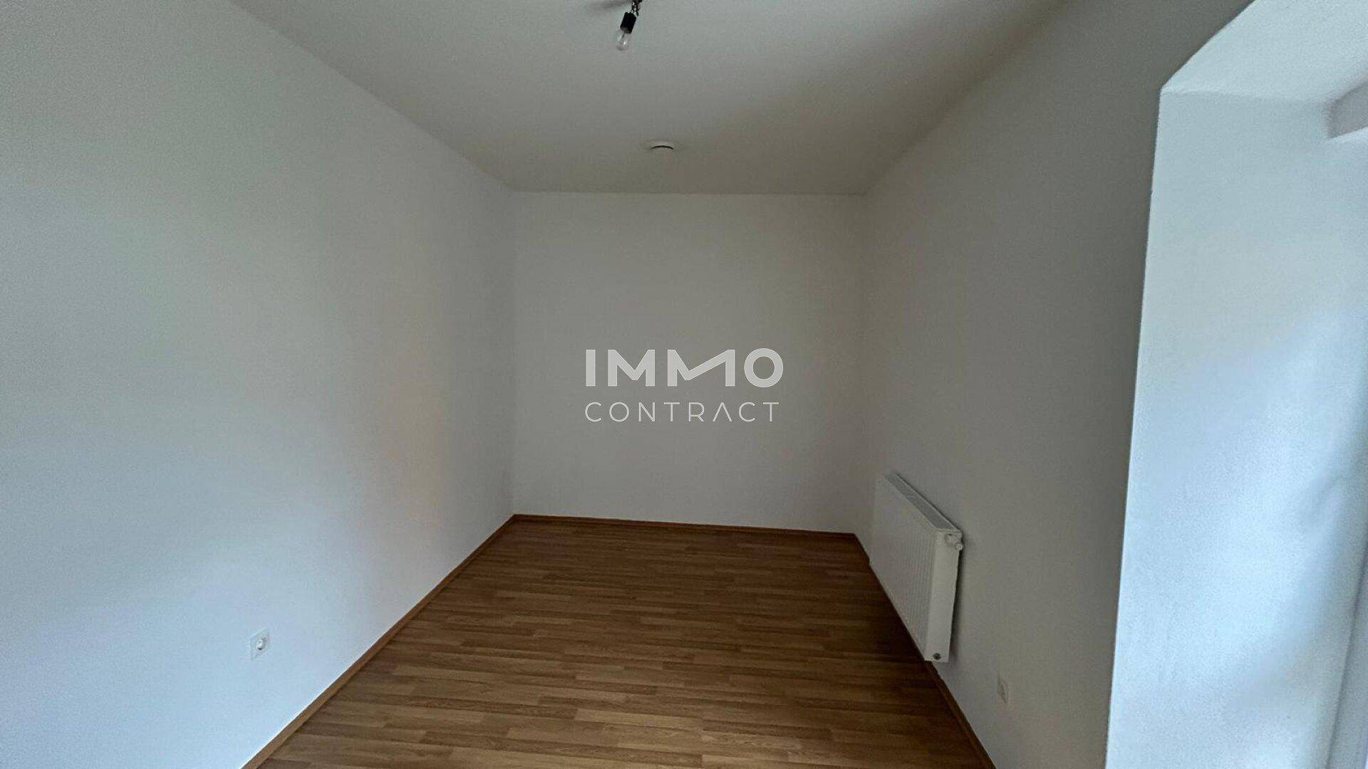 Leeres Zimmer mit hellem Parkettboden und weiß gestrichenen Wänden, bereit zur individuellen Gestaltung.