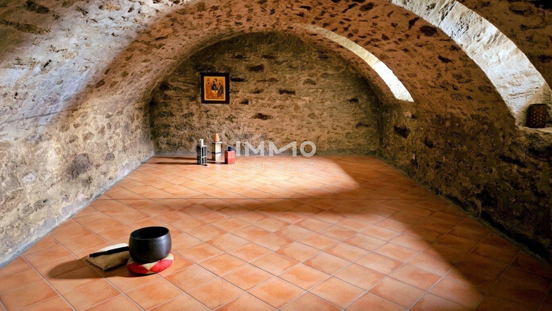 Historischer Gewölbekeller mit Natursteinwänden und Terrakottafliesen, ideal für Lagerung.