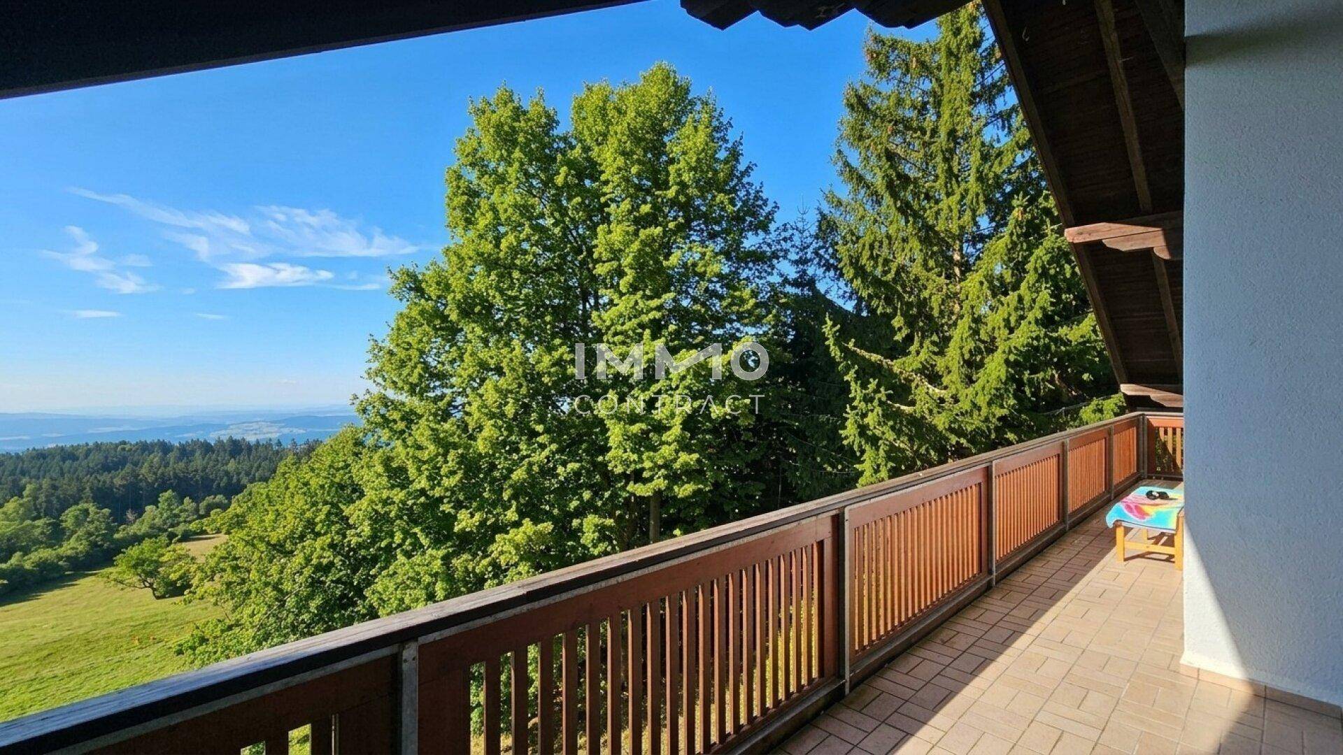 Langer Balkon mit Holzbalkon und weitem Blick über die grüne Landschaft.