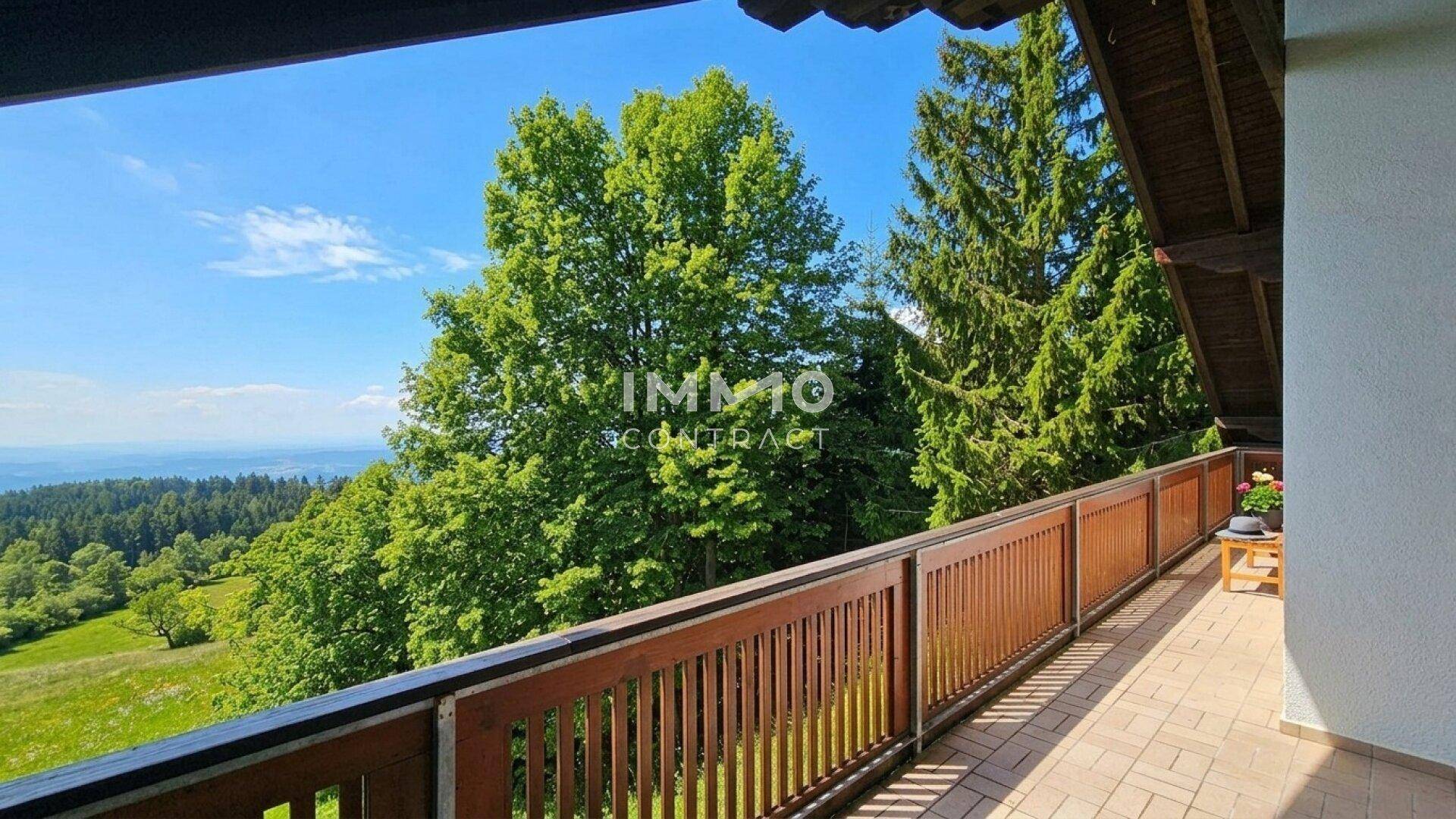 Geräumiger Balkon mit Holzgeländer und atemberaubendem Blick auf die grüne Landschaft.