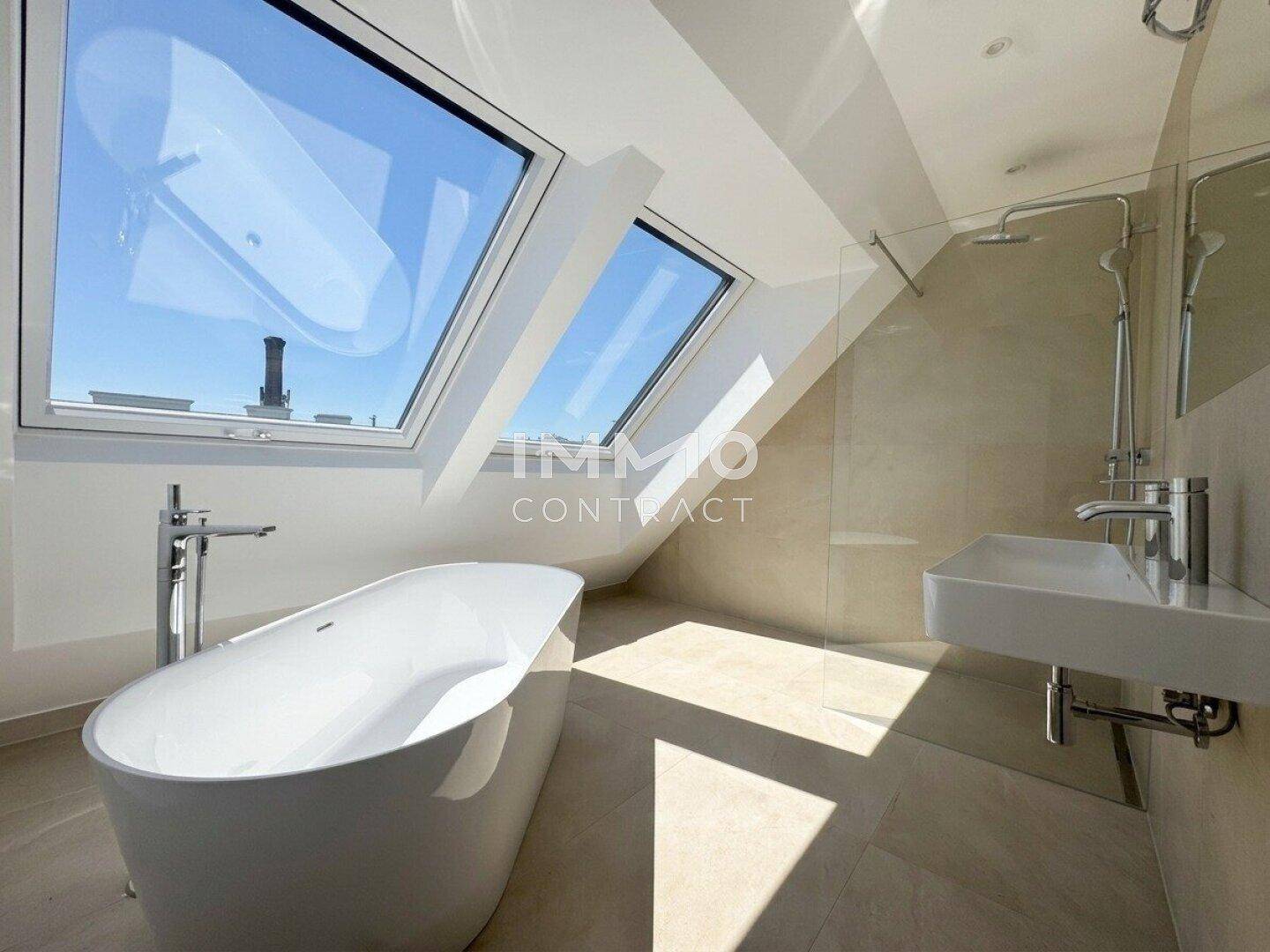 Modernes Badezimmer mit freistehender Badewanne, Dusche und Dachfenstern.