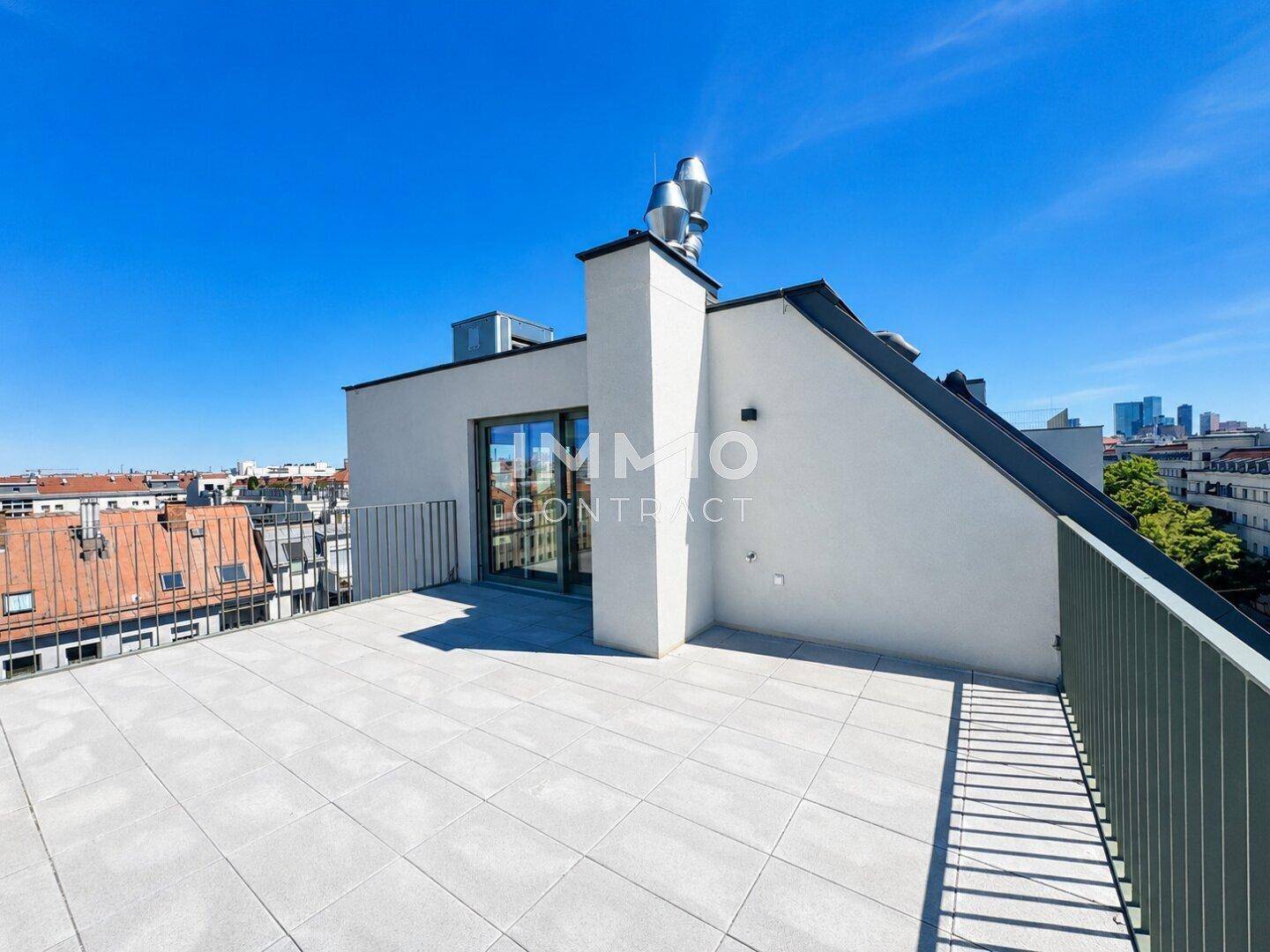 Geräumige Dachterrasse mit Zugang zum Innenbereich und weitem Stadtblick.