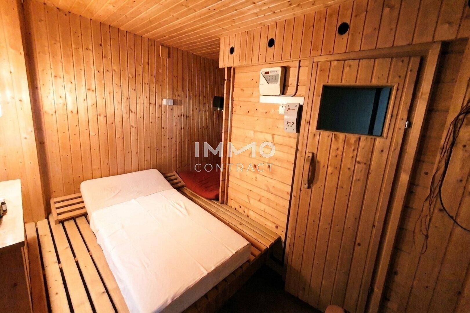 Gemütlicher Saunabereich mit Holzverkleidung und Liegefläche für Entspannung.