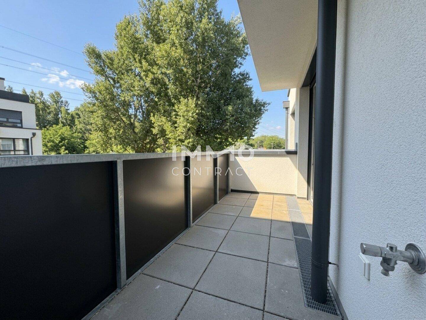 Geräumiger Balkon mit Fliesenboden und Blick ins Grüne, ideal zum Entspannen.