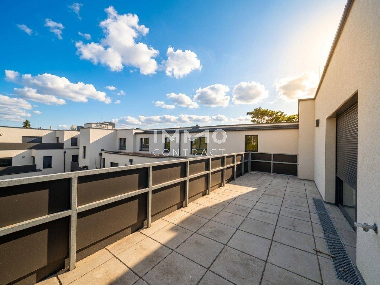 Geräumige Dachterrasse mit Fliesenboden und weitem Blick über die umliegende Bebauung.