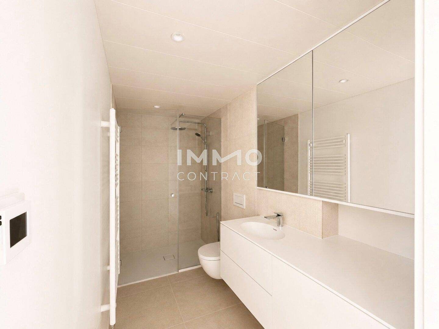 Modernes Badezimmer mit ebenerdiger Dusche, Einzelwaschbecken und beheiztem Handtuchhalter.